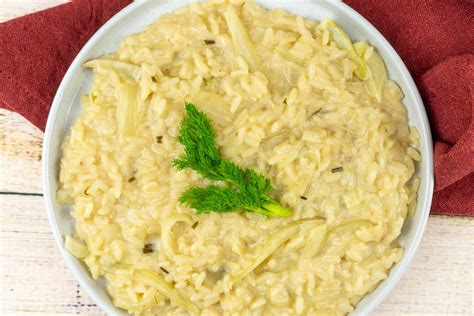 Foto di un piatto di risotto ai finocchi guarnito con pinoli e pepe nero