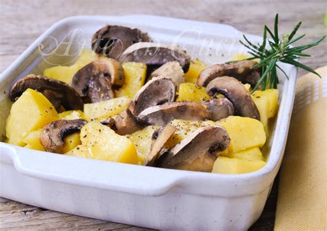Una teglia da forno con seppie, funghi champignon e patate dorate, pronte per essere servite.