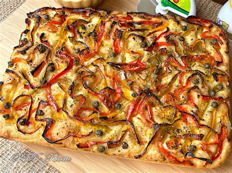 Teglia con peperoni tagliati a falde, cosparsi di panatura e pronti per essere infornati