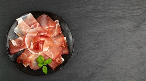 Illustrazione colorata di un piatto di prosciutto crudo e un risotto fumante