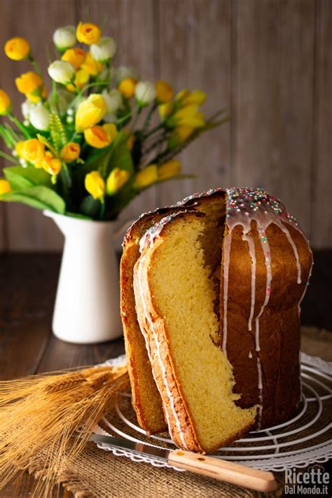Una fetta di crescia dolce di Pasqua decorata con glassa e zuccherini colorati, mostrando l'uvetta e i canditi all'interno.