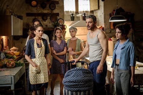 Una foto d'epoca di una famiglia che lavora l'impasto per la torta di Pasqua davanti a un forno a legna comunitario.