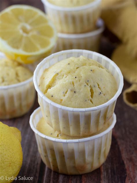 Primo piano di muffin al limone e fragole appena sfornati, con fragole fresche e scorza di limone visibili.