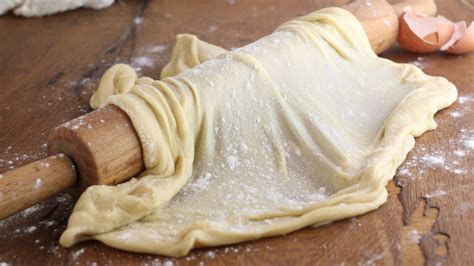 Una sfoglia di pasta tirata per strudel stesa sottilmente su un canovaccio