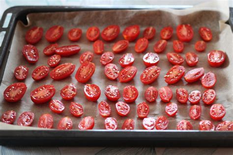 pomodorini ciliegino tagliati a metà su una teglia con carta forno