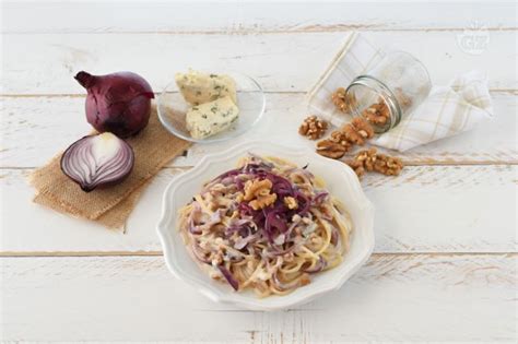 Piatto finito di spaghetti con gorgonzola, noci e cipolle rosse