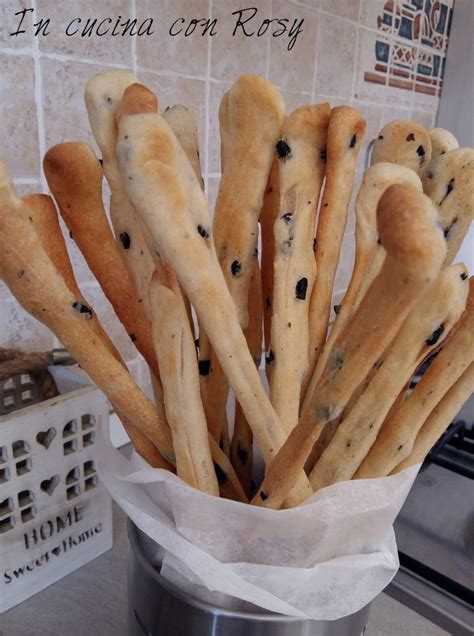 grissini alle olive crudi disposti su teglia da forno pronti per la cottura