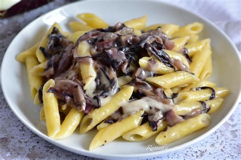 dettaglio di pasta con radicchio e speck croccante, guarnita con pinoli