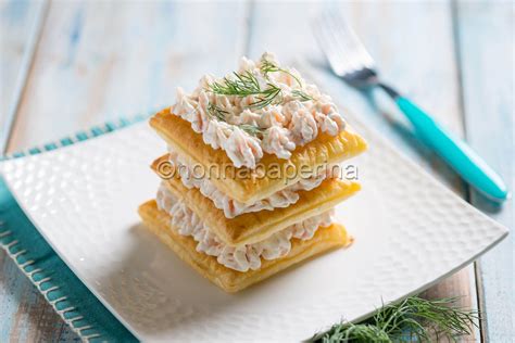 Disposizione a strati di una millefoglie di patate con salmone e Philadelphia