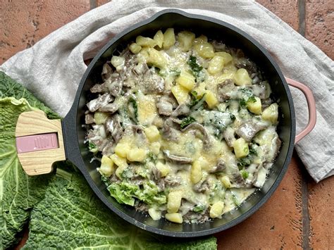 Assemblaggio a strati dei pizzoccheri con formaggio e condimento.