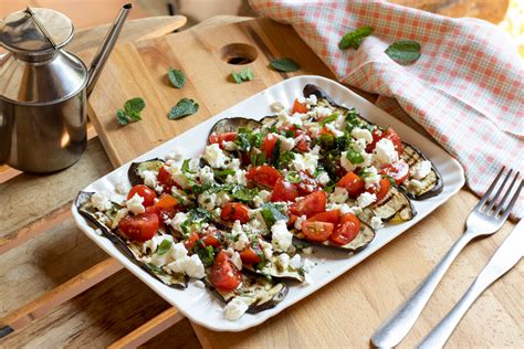 Composizione finale di un'insalata estiva con melanzane, feta e pomodorini