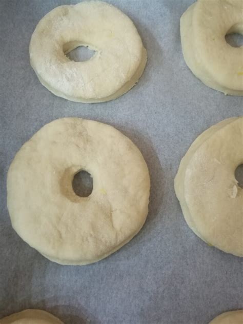 ciambelle gonfie dopo la seconda lievitazione, con scorze di agrumi visibili