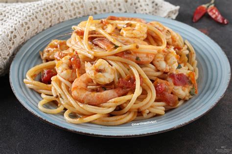Un piatto di pasta con gamberi, pomodorini e prezzemolo fresco, pronto per essere servito.
