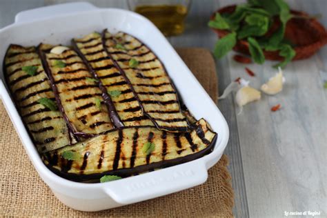 melanzane grigliate disposte a strati in una pirofila con condimenti