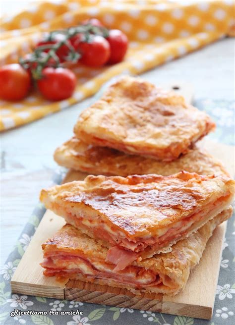 Una torta rustica lievitata con prosciutto e mozzarella, tagliata a fette per mostrare il ripieno filante