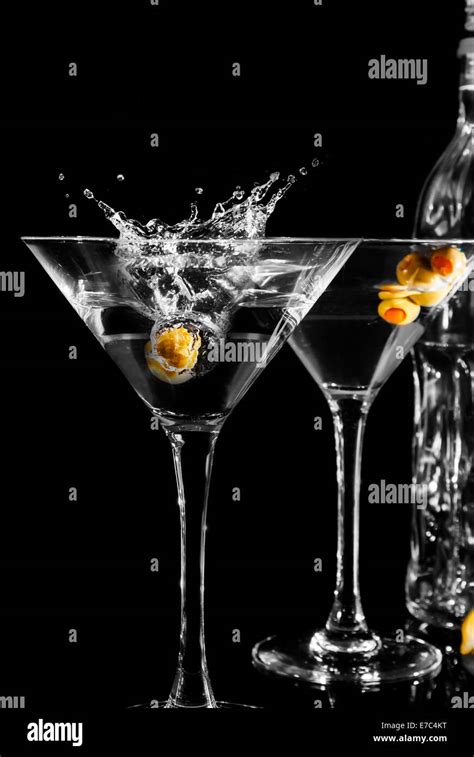 Una coppetta Martini elegante con un cocktail verde brillante, guarnito con granella di pistacchio e fiocchi di cocco sul bordo.