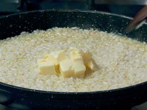 Mantecatura del risotto con burro e parmigiano grattugiato