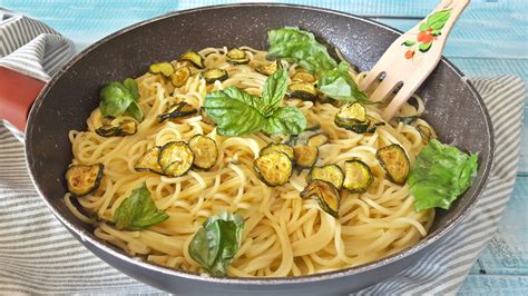 Immagine ravvicinata di un piatto di Spaghetti alla Nerano, con zucchine, formaggio filante e basilico