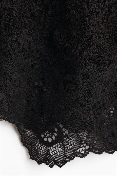 Collage di immagini storiche di moda con pizzo nero, inclusi riferimenti a Dior e Dolce&Gabbana