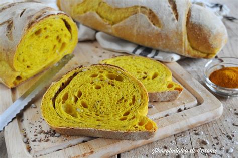 Dettaglio di semi di lino e curcuma sparsi su una superficie, con un accenno di impasto per focaccia sullo sfondo.