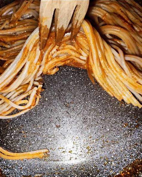Padella con spaghetti in cottura, formando una crosticina scura