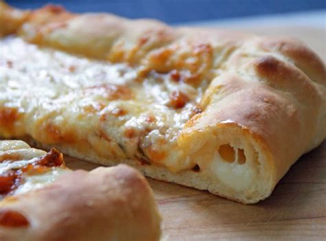 Foto di una pizza filante con bordo ripieno di mozzarella