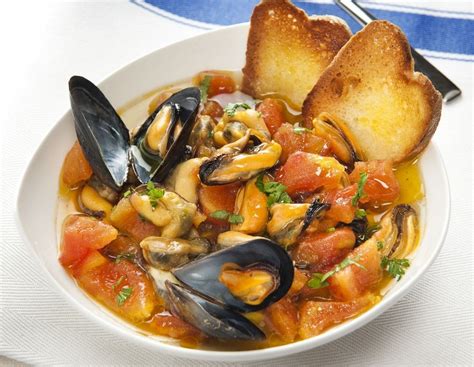 Illustrazione di un piatto di zuppa di cozze fumante con crostoni di pane dorati.