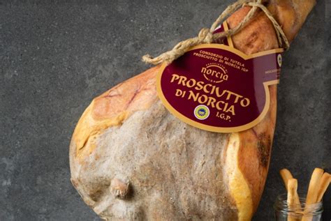 Un'immagine che mostra le etichette IGP del Prosciutto di Norcia e delle Lenticchie di Castelluccio, con una spiegazione dei marchi.
