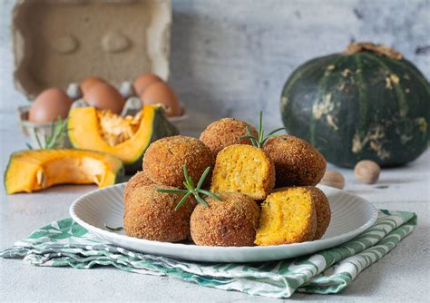 Una ciotola con gli ingredienti per le polpette di zucca: purea di zucca, uovo, formaggio grattugiato, pangrattato, salvia, sale e pepe.