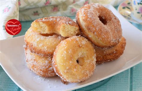 Graffe napoletane fritte, dorate e ricoperte di zucchero semolato, pronte per essere gustate.