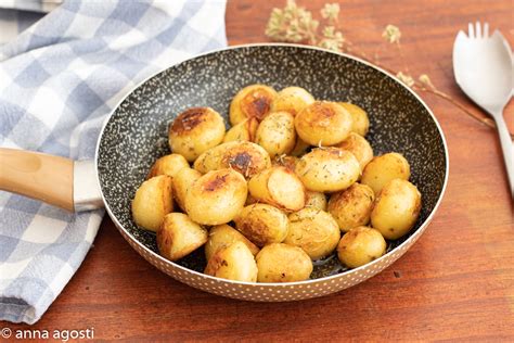 padella con patate novelle condite con rosmarino e aglio pronte per essere infornate