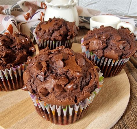 Vista dall'alto di muffin al cacao senza glutine decorati con ganache e frutti di bosco