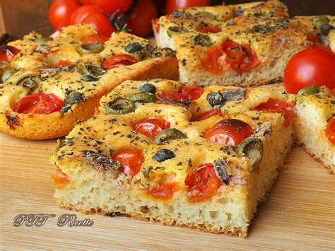 Composizione di focacce con diverse guarnizioni: cipolle, pomodorini e olive, erbe aromatiche