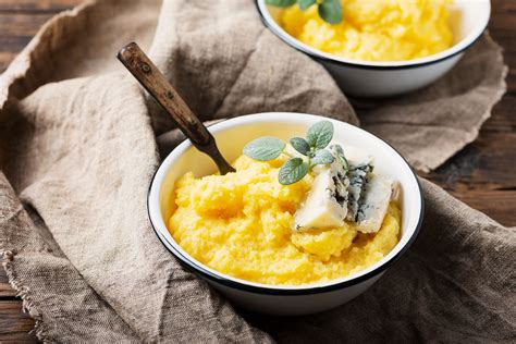Una ciotola fumante di polenta morbida, con un cucchiaio affondato