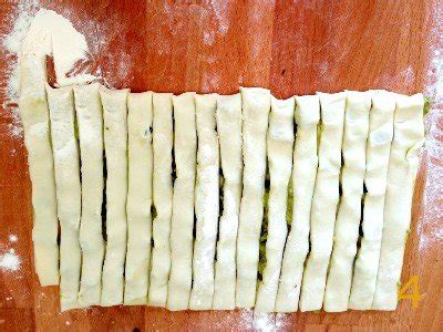 Dettaglio della disposizione degli ingredienti su una striscia di pasta sfoglia prima di arrotolarla