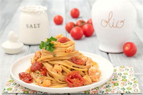 Immagine di scampi freschi e pomodorini ciliegino, ingredienti chiave della ricetta.