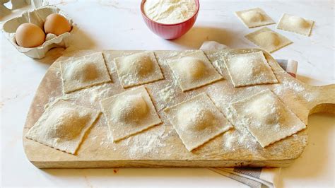 Immagine di ravioli fatti a mano disposti su un vassoio.