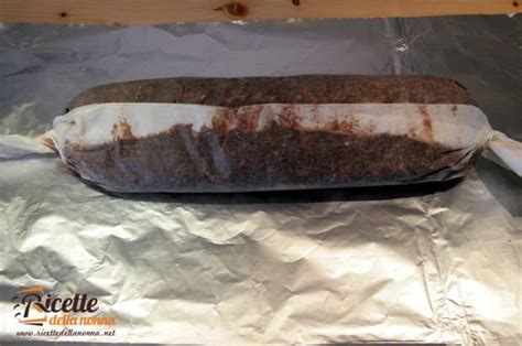 Il salame di cioccolato avvolto in carta da forno e alluminio pronto per il riposo in frigo