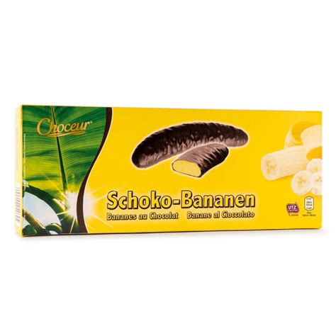 Banane ricoperte al cioccolato, decorate con granella di frutta secca e cocco, disposte su un piatto da portata.