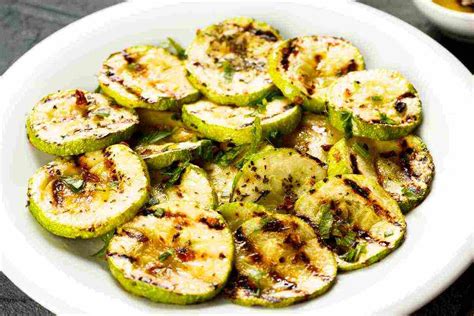 piatto di zucchine grigliate condite con erbe aromatiche