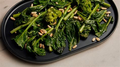 Primo piano di cime di rapa fresche su un tagliere di legno.