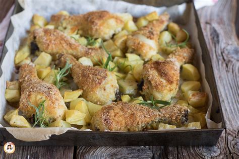 Pezzi di pollo dorati e patate croccanti in una teglia da forno