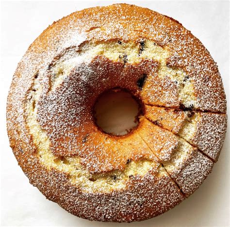una ciambella alla panna soffice e dorata, spolverizzata con zucchero a velo