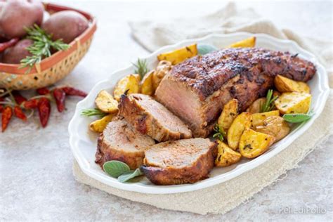 Filetto di maiale marinato con erbe aromatiche, pronto per la cottura in forno.