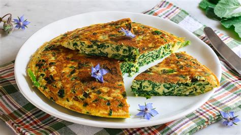 Frittata di borragine servita su un piatto da portata, guarnita con fiori di borragine