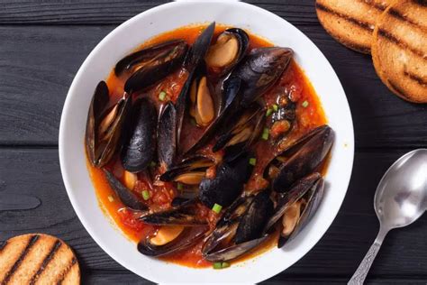 Immagine di una zuppa di cozze alla sarda fumante con pane tostato