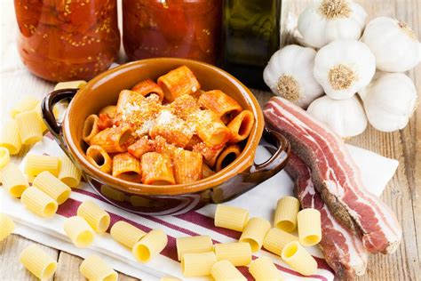 Schema: Ingredienti del sugo alla zingara disposti su un tagliere (pancetta, peperoni, funghi, cipolla, aglio)