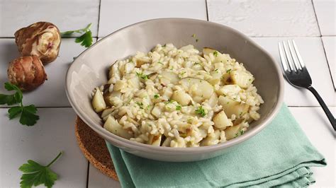 Risotto al topinambur pronto, impiattato e guarnito con prezzemolo fresco