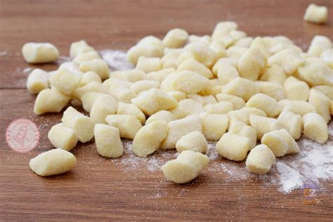Mani che preparano gli gnocchi di patate con un classico riga gnocchi