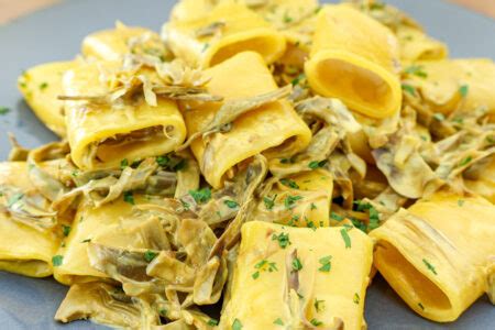 piatto di paccheri carciofi e zafferano impiattato con guarnizione di prezzemolo fresco